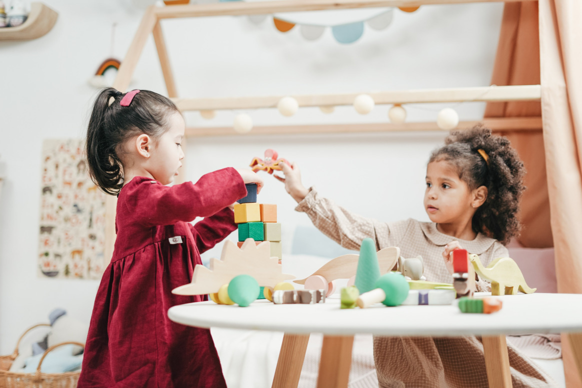 Two young children participating in play therapy for kids, using blocks and toys to develop social skills, problem-solving, and cooperative play in a structured environment.