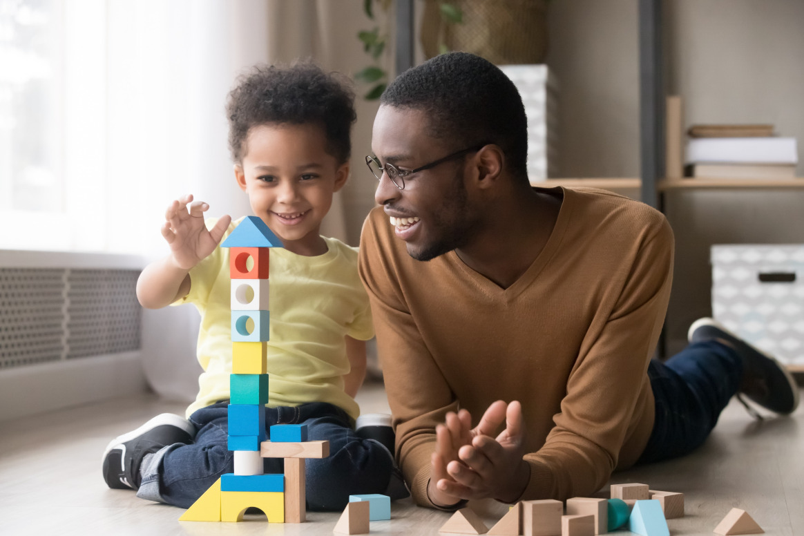 Parent engaging in ABA therapy training for parents, using play-based learning with their child to reinforce developmental skills and positive behavior strategies at home.